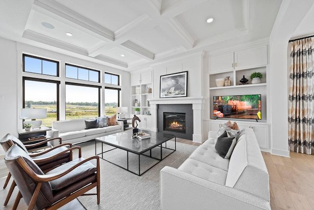 living room with beam ceiling, built in shelves, light hardwood / wood-style flooring, and coffered ceiling