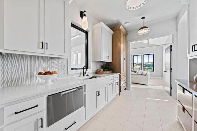 kitchen featuring dishwasher, white cabinets, sink, hanging light fixtures, and tasteful backsplash