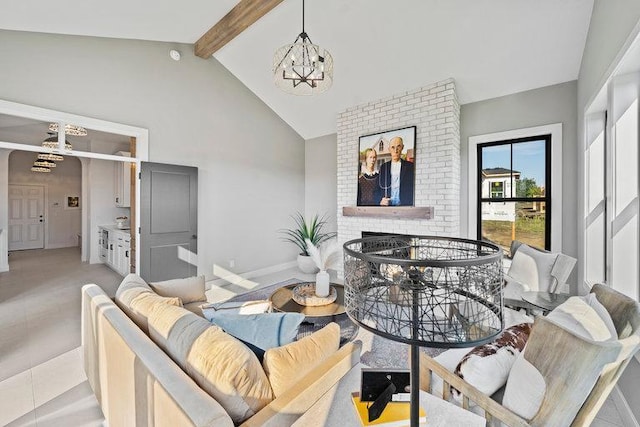 tiled living room featuring a chandelier, lofted ceiling with beams, and a brick fireplace