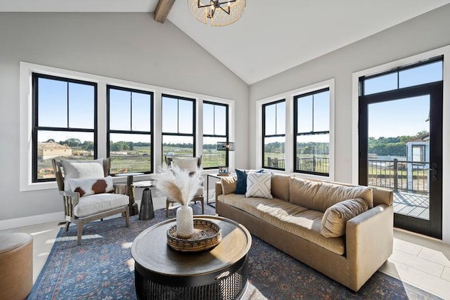 tiled living room with plenty of natural light, beamed ceiling, high vaulted ceiling, and a notable chandelier