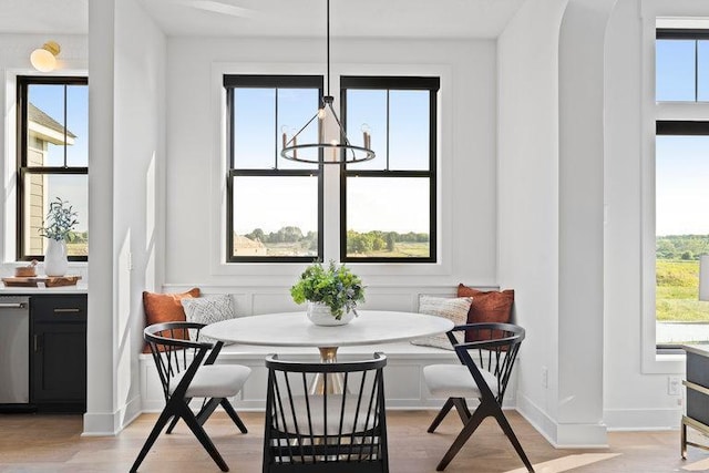 dining room featuring a chandelier, breakfast area, light wood-style flooring, and baseboards