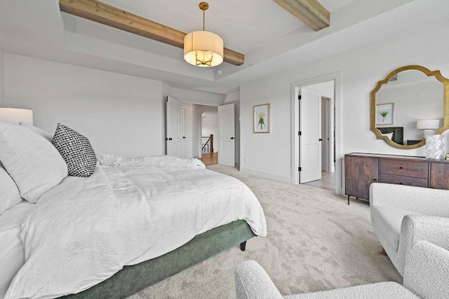 bedroom with a tray ceiling, beam ceiling, carpet flooring, and baseboards