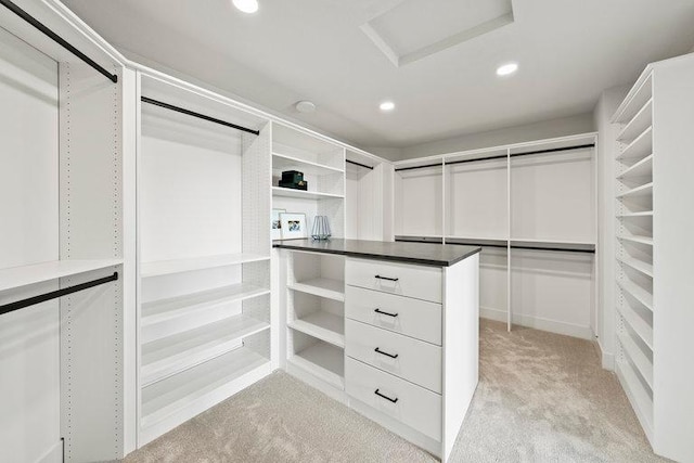 spacious closet with light carpet and attic access