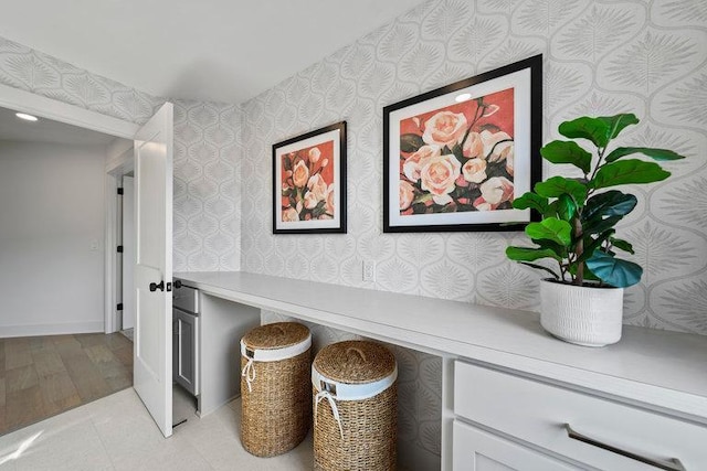 interior space with baseboards and wallpapered walls