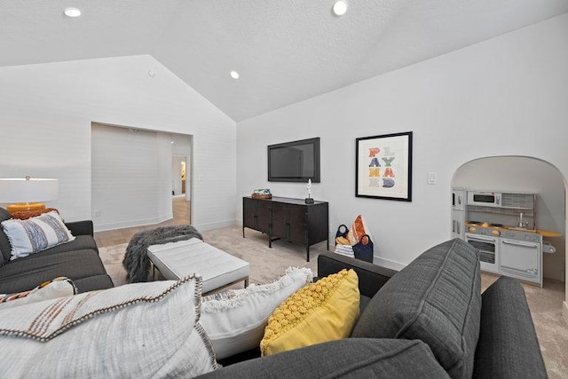 living area with baseboards, arched walkways, light colored carpet, vaulted ceiling, and a textured ceiling