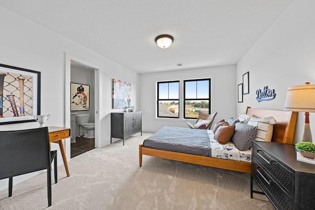 carpeted bedroom with a textured ceiling and connected bathroom