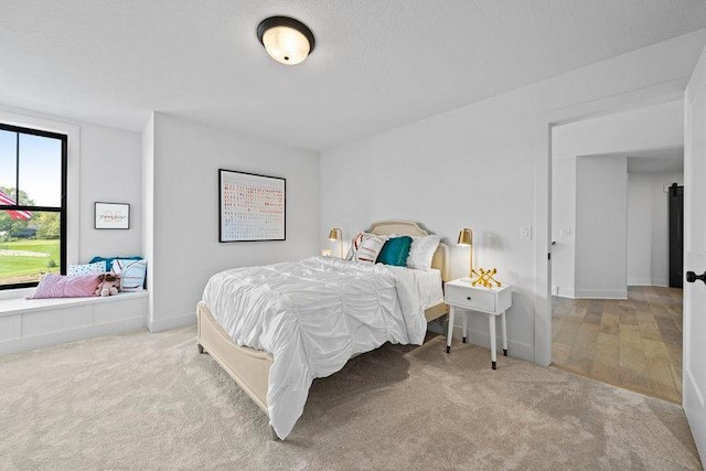 bedroom featuring carpet floors, baseboards, and a textured ceiling