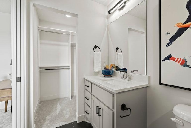 bathroom with toilet, vanity, and baseboards