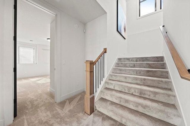 stairway featuring carpet floors and baseboards