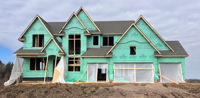 property under construction featuring a shingled roof, an outdoor structure, and a barn