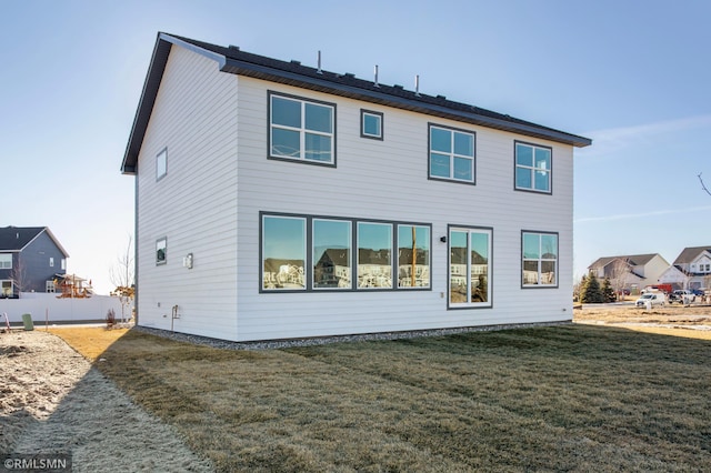 back of house featuring a lawn