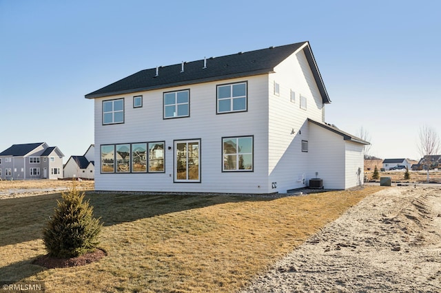 back of house featuring central AC unit and a lawn