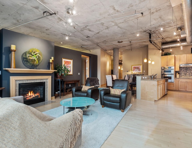 living room with light hardwood / wood-style flooring and sink