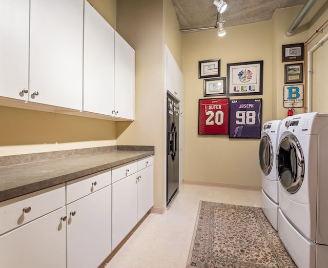 clothes washing area featuring cabinets, separate washer and dryer, and track lighting