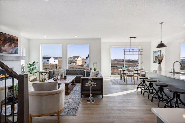 living room featuring a textured ceiling, plenty of natural light, dark hardwood / wood-style flooring, and sink