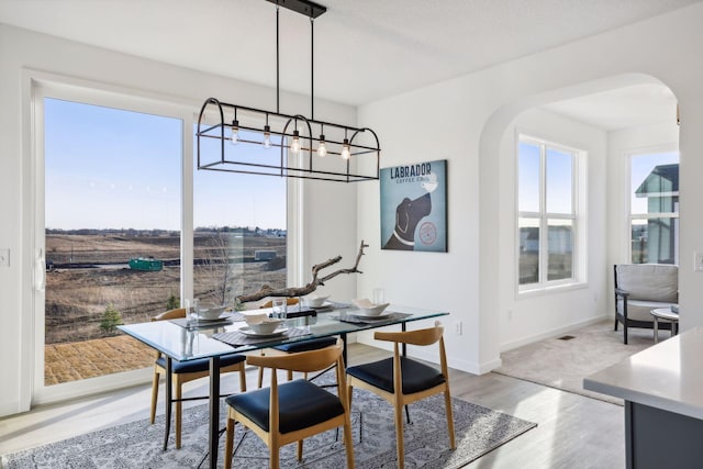 dining room featuring a textured ceiling, light hardwood / wood-style flooring, and a notable chandelier