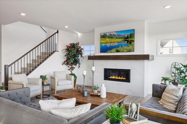 living room with a tile fireplace and hardwood / wood-style flooring