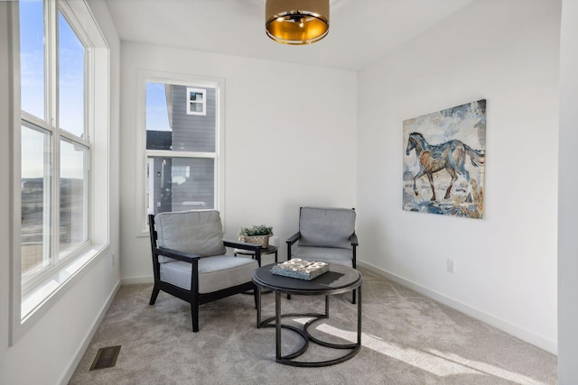 sitting room with a wealth of natural light and light colored carpet