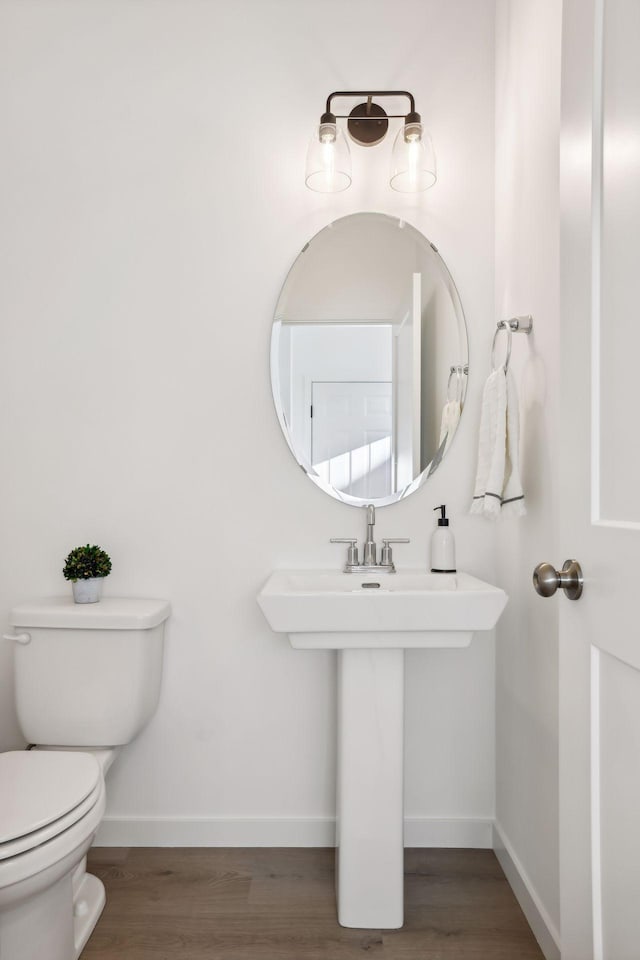 bathroom with hardwood / wood-style floors and toilet