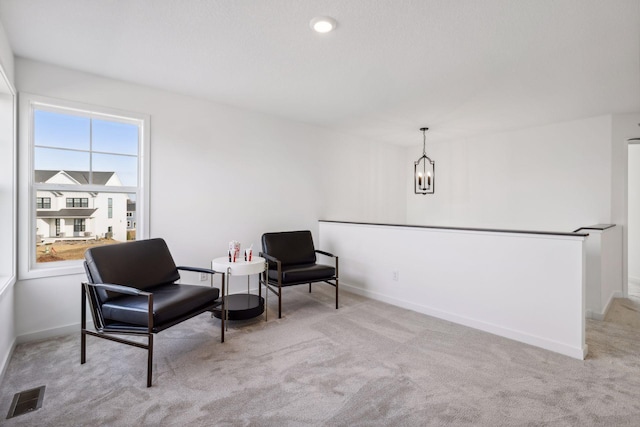 sitting room featuring light colored carpet and a notable chandelier