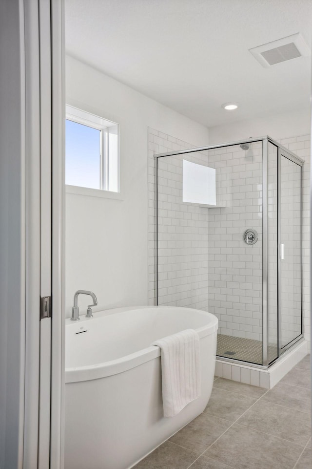 bathroom with tile patterned flooring and separate shower and tub