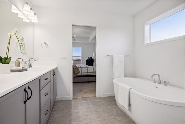 bathroom with tile patterned flooring, a washtub, and vanity