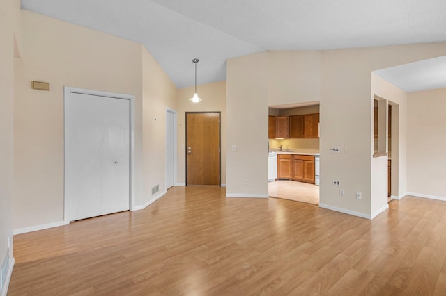 unfurnished living room featuring visible vents, light wood-style flooring, high vaulted ceiling, and baseboards