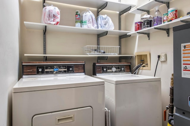 clothes washing area featuring laundry area, water heater, and washer and clothes dryer