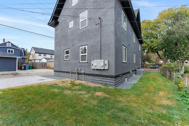 view of home's exterior with a lawn and central air condition unit