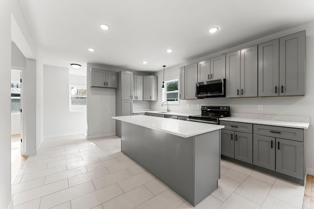 kitchen featuring a center island, gray cabinets, plenty of natural light, and black / electric stove