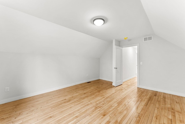 bonus room featuring vaulted ceiling and light hardwood / wood-style flooring