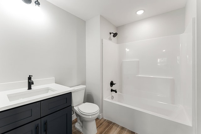 full bathroom featuring bathing tub / shower combination, vanity, hardwood / wood-style flooring, and toilet