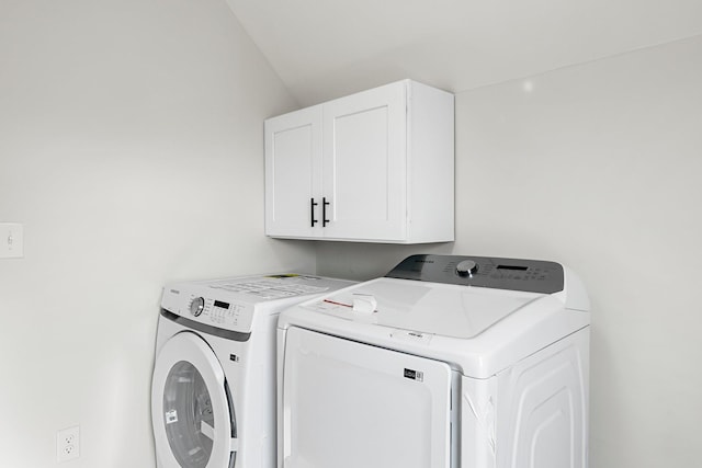 washroom featuring cabinets and independent washer and dryer