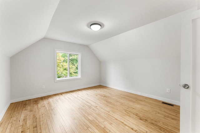 bonus room with light hardwood / wood-style flooring and lofted ceiling