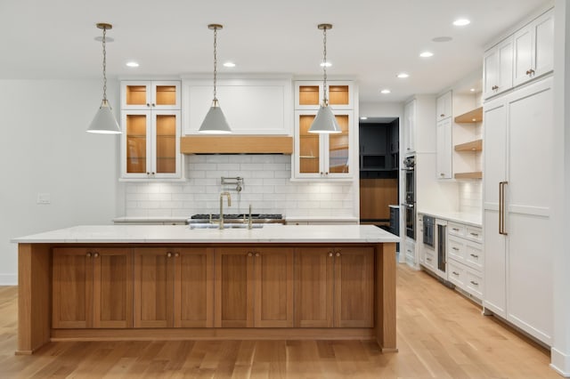 4023 Beard Ave S, Minneapolis, MN 55410 - kitchen with light wood finished floors, tasteful backsplash, white cabinetry, open shelves, and stainless steel double oven