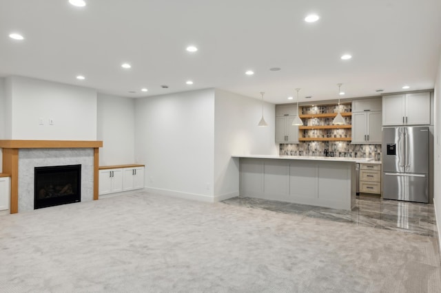 unfurnished living room featuring light carpet and a fireplace