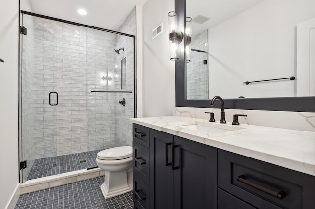 bathroom with tile patterned floors, vanity, a shower with shower door, and toilet