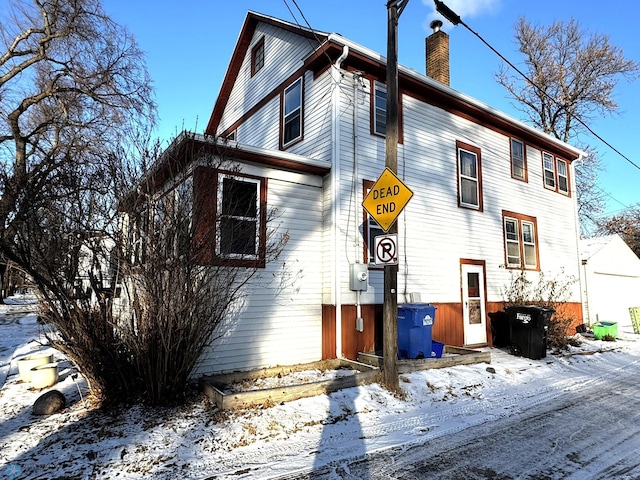 view of snow covered rear of property