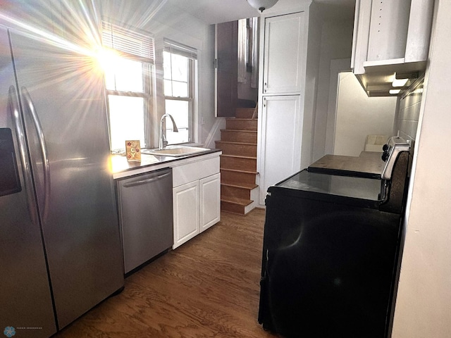 kitchen featuring appliances with stainless steel finishes, dark hardwood / wood-style floors, white cabinetry, and sink