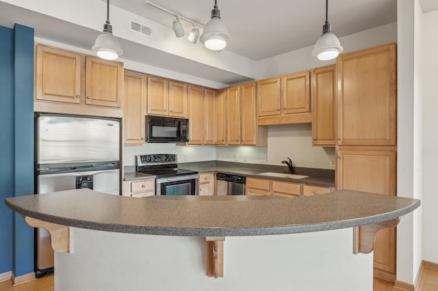 kitchen with a breakfast bar, appliances with stainless steel finishes, light brown cabinetry, and sink