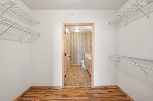 walk in closet featuring light hardwood / wood-style flooring