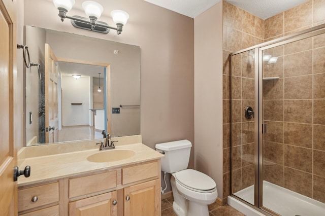 bathroom with a textured ceiling, vanity, toilet, and walk in shower