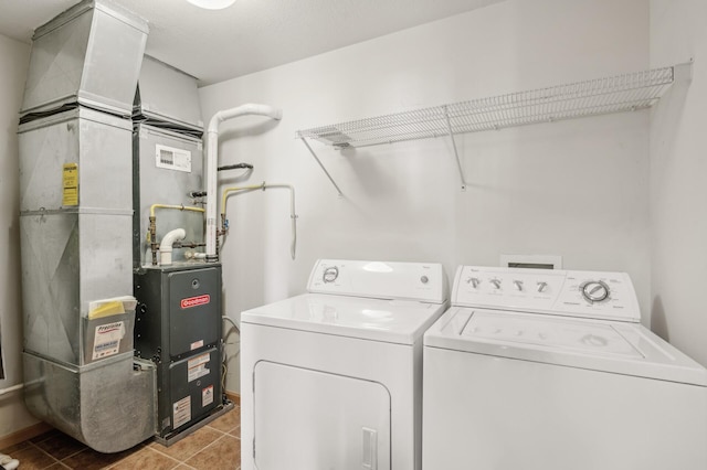 clothes washing area with independent washer and dryer, a textured ceiling, light tile patterned floors, and heating unit