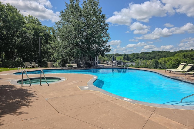 view of pool with a patio and a hot tub