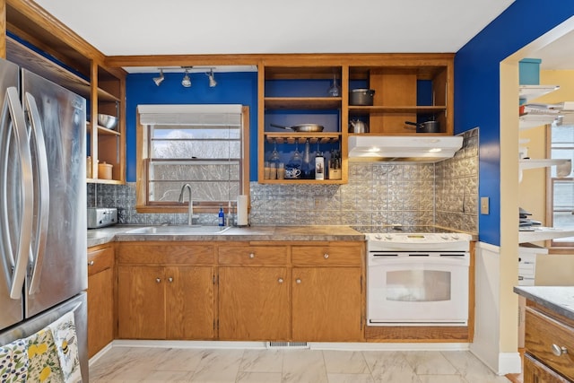 kitchen with stainless steel refrigerator, sink, ventilation hood, backsplash, and stove