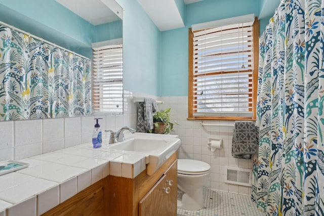 bathroom with tile patterned floors, plenty of natural light, vanity, and toilet