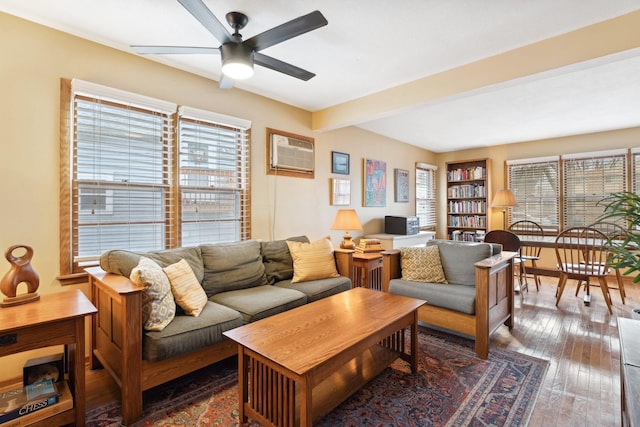 living room featuring a wealth of natural light, ceiling fan, a wall mounted air conditioner, and dark hardwood / wood-style floors