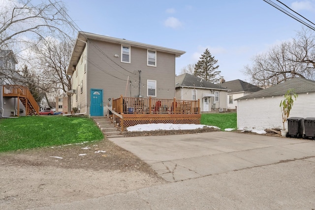 rear view of house featuring a yard and a wooden deck