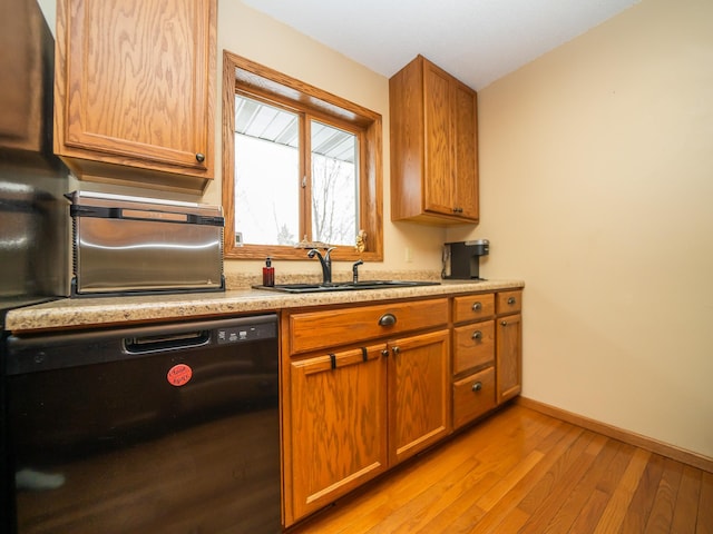 kitchen with light wood-type flooring, dishwasher, and sink