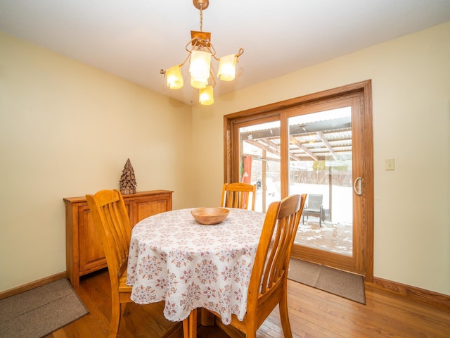 dining room with wood-type flooring and an inviting chandelier